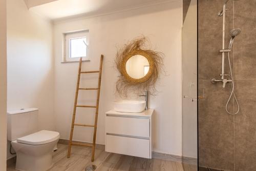 a bathroom with a toilet and a mirror at Villa Principezinho in Portimão