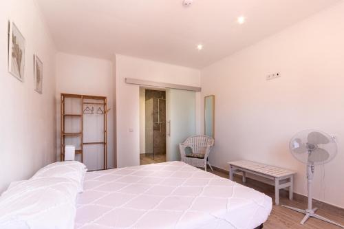 a white bedroom with a large bed and a desk at Villa Principezinho in Portimão