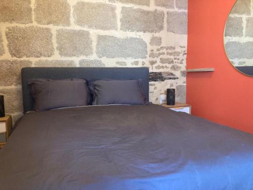 a bed in a room with a brick wall at Gîte des granges in Alençon