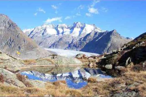 a mountain range with a reflection in a body of water at Fiesch-Lax Minnig Moritz in Lax