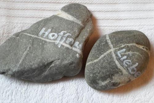 two rocks withhens written on them on a bed at Fiesch-Lax Minnig Moritz in Lax