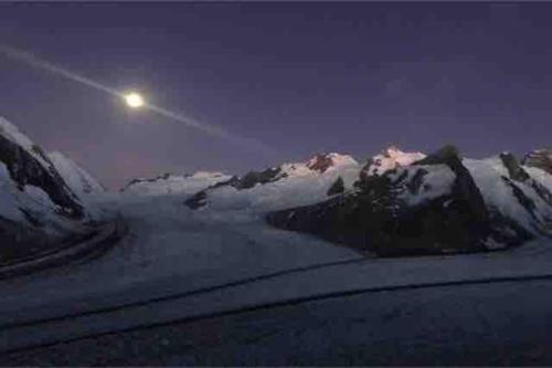 a moon over a snow covered mountain at night at Fiesch-Lax Minnig Moritz in Lax