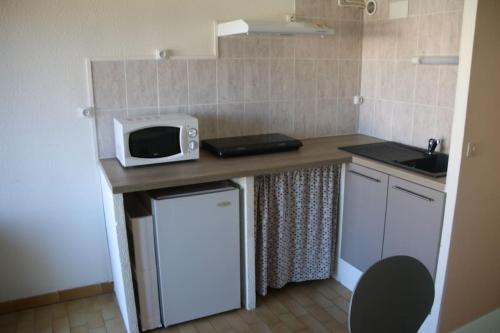 een kleine keuken met een magnetron op een aanrecht bij Studio 141 Port Soleil B1 au village naturiste in Cap d'Agde