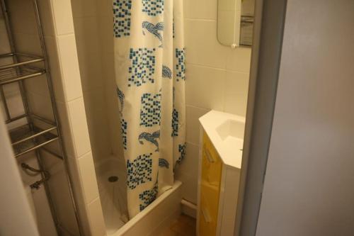 een badkamer met een douchegordijn en een wastafel bij Studio 141 Port Soleil B1 au village naturiste in Cap d'Agde