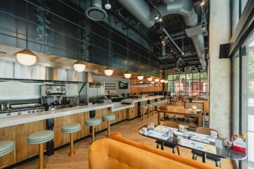 a restaurant with tables and chairs and a kitchen at Origin Austin, a Wyndham Hotel in Austin
