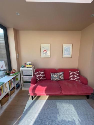 a living room with a red couch in a room at Beautiful Family-Friendly 4BD House - North Sheen in Kew Gardens
