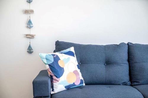 a blue couch with a pillow in a living room at Xenos Villa 6 with a Private pool near the sea in Tigaki