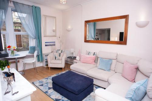 a living room with a white couch and a mirror at Bees Townhouse- Cupar in Cupar