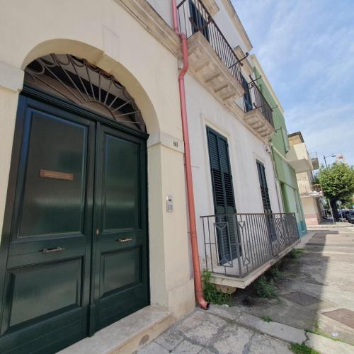 a building with a green door on a street at Dalla zia Maristella in Novoli