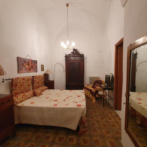een slaapkamer met een bed en een kroonluchter bij Dalla zia Maristella in Novoli