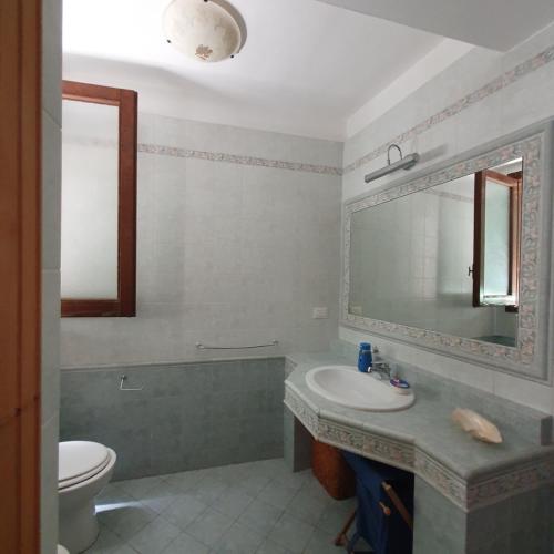 La salle de bains est pourvue d'un lavabo, de toilettes et d'un miroir. dans l'établissement Dalla zia Maristella, à Novoli