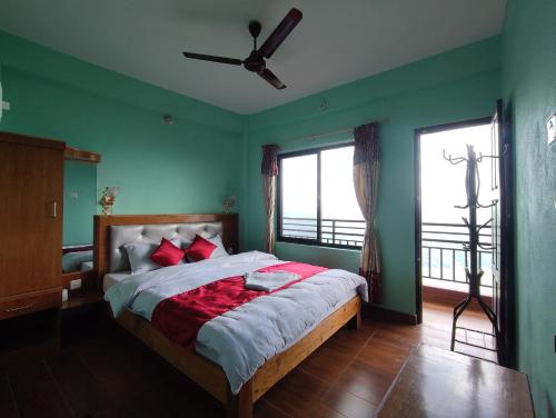 a bedroom with green walls and a bed with red pillows at Sarangkot Hotel New Galaxy in Pokhara