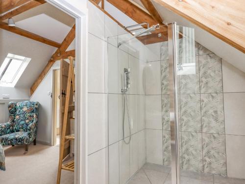 a bathroom with a glass shower in a attic at The Coach House at Thorn Farm in Exeter