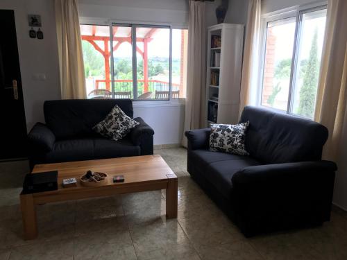 Sala de estar con 2 sofás y mesa de centro en RnR BednBreakfast, en Caspe