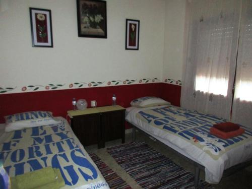 ein Schlafzimmer mit 2 Betten und einem Tisch darin in der Unterkunft RnR BednBreakfast in Caspe