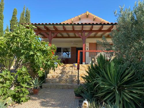 ein Haus mit einer Pergola im Garten in der Unterkunft RnR BednBreakfast in Caspe