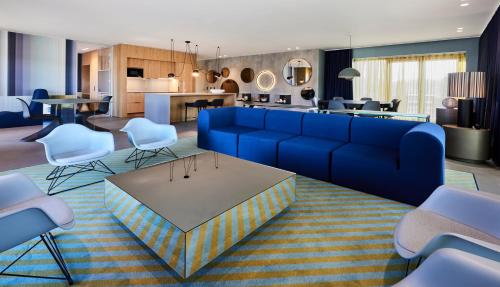 sala de estar con sofá azul y sillas en Kirk Suites, en Vejle