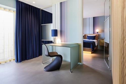 a room with a desk and a chair and a bed at Kirk Suites in Vejle