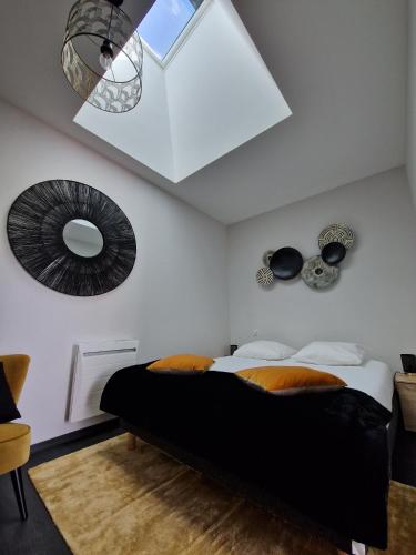 une chambre avec un lit noir et un plafond avec un miroir dans l'établissement Domaine Grand Piquecaillou - L'appartement Sainte-Croix-Du-Monts, à Saint-Maixant