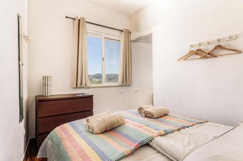 ein Schlafzimmer mit einem Bett mit zwei Kissen darauf in der Unterkunft Casa do Vento Townhouse in Aljezur