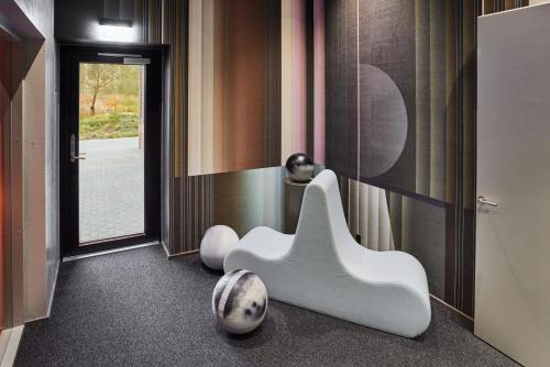 a bathroom with two white chairs and a mirror at Kirk Suites in Vejle