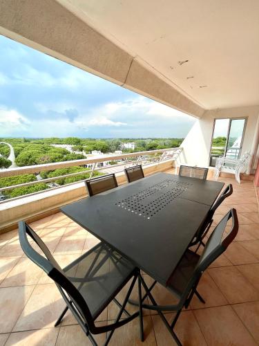 une table noire et des chaises sur un balcon dans l'établissement Coeur de ville avec piscine Appartement t4 pour 6 personnes N113, à La Grande Motte