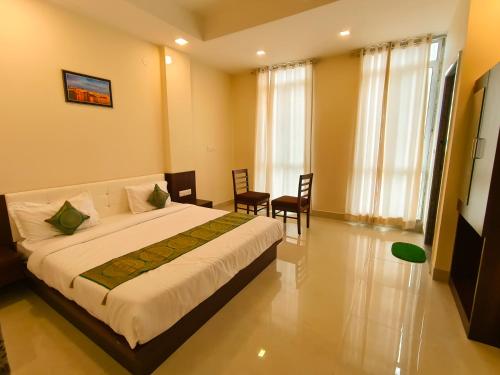 Hotel Veer Palace near Udaipole Udaipur في أودايبور: غرفة نوم بسرير وطاولة وكراسي