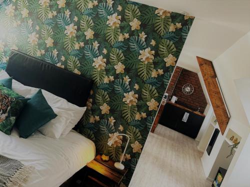 a bedroom with a bed and a wall with flowers at Cardiff Arms Bistro & Hotel in Treorky