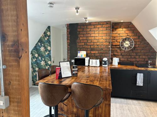 a kitchen with a counter with chairs and a table at Cardiff Arms Bistro & Hotel in Treorky