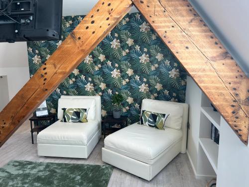 two white chairs in a room with floral wallpaper at Cardiff Arms Bistro & Hotel in Treorky