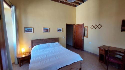 a bedroom with a bed and a table and a window at Casa Katharina - Valle Gran Rey in Calera