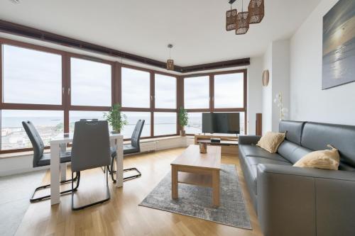a living room with a couch and a table at Dom & House - Apartamenty Sea Towers in Gdynia