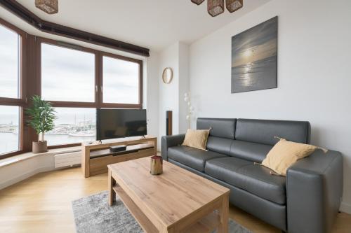 a living room with a couch and a coffee table at Dom & House - Apartamenty Sea Towers in Gdynia