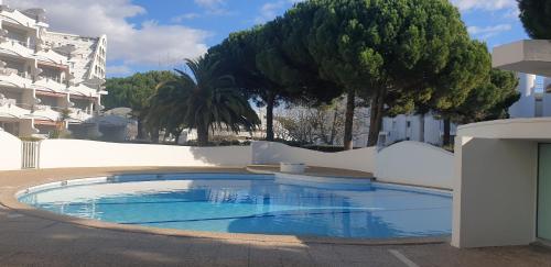 une piscine au milieu d'un immeuble dans l'établissement Quartier Couchant Appartement studio pour 2 personnes N2 121, à La Grande Motte