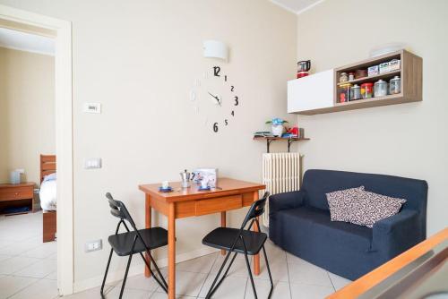 uma sala de estar com uma mesa e um sofá azul em River Apartment - Affitti Brevi Italia em Lecco