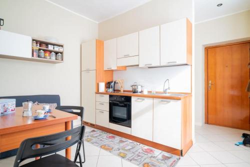 uma cozinha com armários brancos e uma mesa de madeira em River Apartment - Affitti Brevi Italia em Lecco