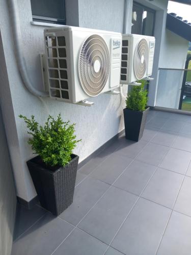 two air conditioners on the side of a building with plants at Casa Ambientt in Curtea de Argeş