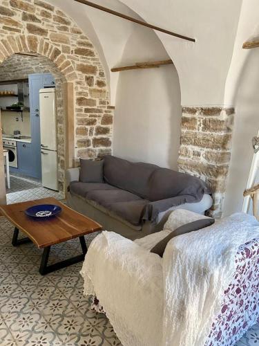 ein Wohnzimmer mit einem Sofa und einem Tisch in der Unterkunft Cozy stone built apartment in Nénita! in Chios