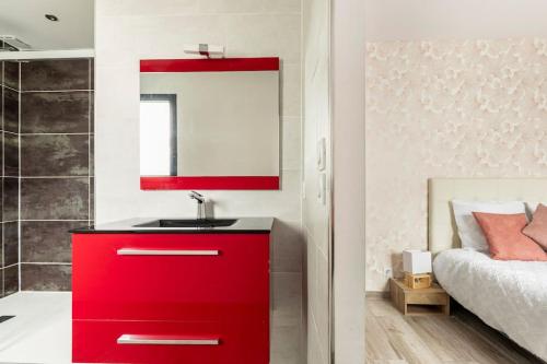 - une armoire rouge avec lavabo dans la chambre dans l'établissement Villa des rives du Tarn avec jacuzzi, à Montans