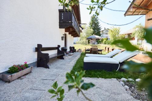 a patio with two couches on the side of a building at Ferienwohnung Hubert in Rottach-Egern