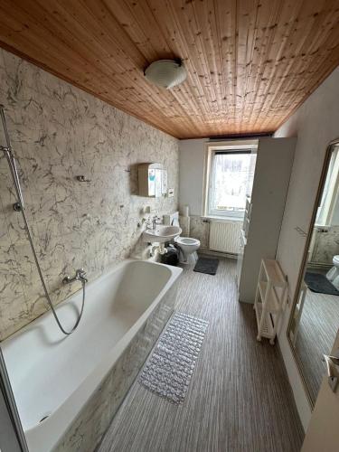 a bathroom with a bath tub and a sink at Demir Pension in Gronau