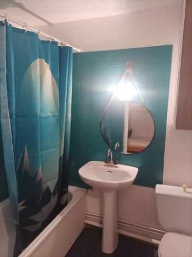 une personne prenant une photo d'une salle de bains avec lavabo dans l'établissement Studio Morillon Village, à Morillon