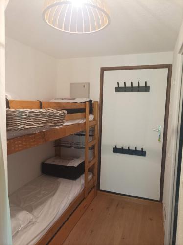 Zimmer mit 2 Etagenbetten und einem Spiegel in der Unterkunft Studio Morillon Village in Morillon