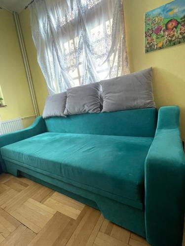 a blue couch in a room with a window at CONSTANTINESCU A. in Buşteni
