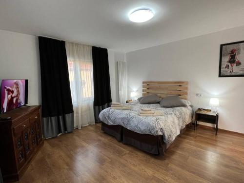 Schlafzimmer mit einem großen Bett mit einem Kopfteil aus Holz in der Unterkunft Ambra Dream Home in Câmpulung Moldovenesc