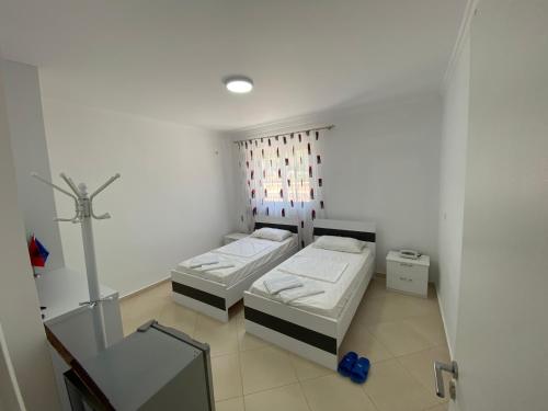 a small room with two beds and a window at Loft Apartments in Sarandë
