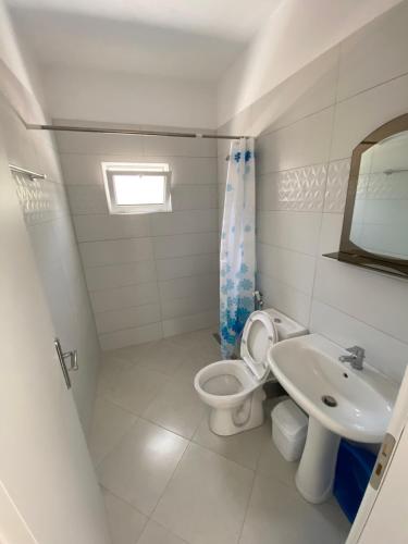 a bathroom with a toilet and a sink at Loft Apartments in Sarandë