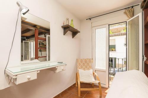 a bedroom with a desk and a bed and a window at Casa Paula in Benamahoma