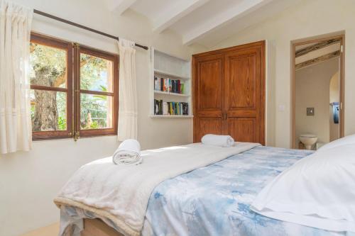 een slaapkamer met een groot bed en een raam bij Ses Begudes in Fornalutx