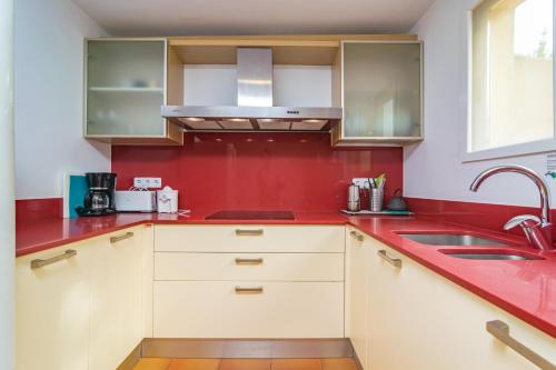 a red kitchen with a sink and a red wall at Ca's Pobres in Sóller